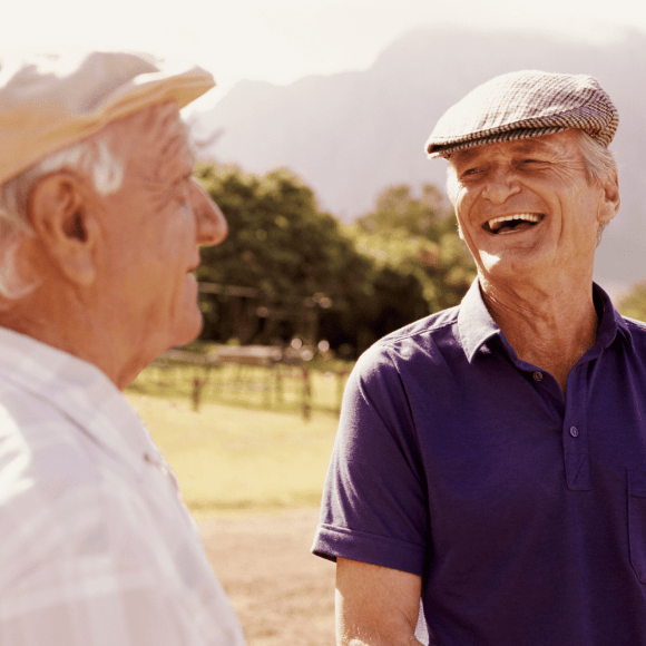 2 men in a farm field laughing