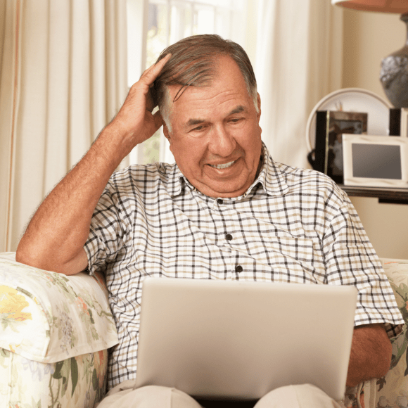 man looking at laptop on couch